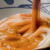 濃厚味噌だしをうどんに注ぐ様子