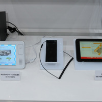 展示されていた専用端末。7インチTFTカラー液晶でFeliCaリーダー/ライターを内蔵した専用端末「CTE-001」（左）と、本サービスに対応する予定（参考出品）の「Galaxy Tab」（右）
