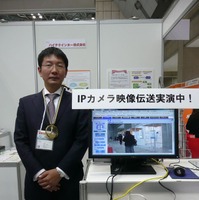 同社のブース内にて、代表取締役 亘尾紀人氏。ABiLINXシリーズを用いて、IPカメラによる画像伝送のデモも実施