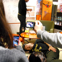 トーク後、酔っ払って座敷に寝転がる会田氏。と、それをケータイで撮る観客たち。