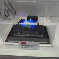 塗布型透明スクリーンも展示。ガラス上に、ナノダイヤモンドを使用した塗料を塗って、透明スクリーンとして利用できる。東京工業大学、ビジョン、ENEOSの3社による共同開発したもの