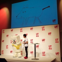 記者会見のゲストは田辺誠一作イラスト「かっこいい犬。」のもっちー（向かって左）と陣内。画面は陣内がTシャツにデザインした犬の原画