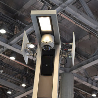 LED照明部分。監視カメラとその下に放送スピーカーがある。両脇のプレートはメッシュネットワーク用の通信アンテナ（撮影：防犯システム取材班）