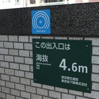 勤務先から北の丸公園に向かう道中に見つけた「東京都耐震マーク」。貼られていた施設は、都営地下鉄及び東京メトロの駅への出入り口で、一緒に海抜表記もあった（撮影：防犯システム取材班）