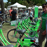 市のフェスティバルで、スタッフがバイクシェアのプログラムと自転車の使い方を住民に紹介している