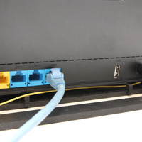 通信ONUのバックパネル。LANポートが全部で3口用意されている。黄色い配線は放送ONUから延びる光ファイバー