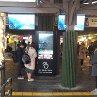 写真中央に見えるのが、嵐山駅に設置されている大型のデジタルサイネージ。縦長の55インチ 4Kタッチパネルと2枚の広告配信用モニター（上面左右に設置）で構成されている