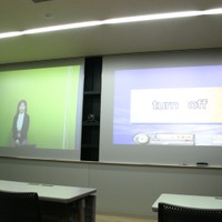 セミナールームの正面：2面のスクリーンパネルはホワイトボードのように使うことができる。真ん中にカメラが設置される