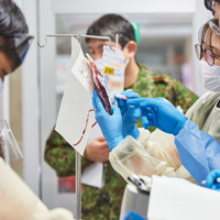 臨時の医療施設に運ばれてきた傷病者を治療する演習で、銃撃で負った傷により多量の血液が失われたという設定の模擬患者に輸血動作を行う自衛官