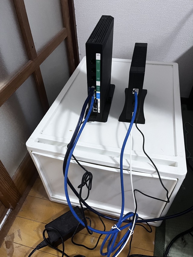 機器背面の接続状況。10G-ONUからXG-100NEのWAN 10Gポートへ青いLANケーブルで接続されている