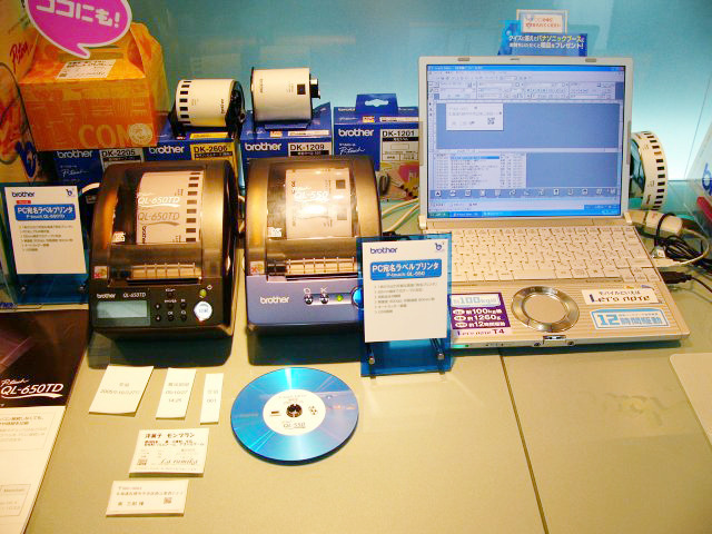 宛名だけでなく、CDラベル用に円形に切り抜ける用紙も揃える感熱紙のPC宛名ラベルプリンタ。左は未発表の「QL-650TD」