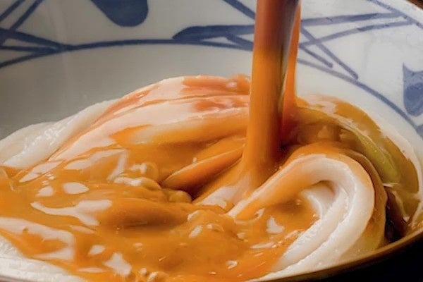 濃厚味噌だしをうどんに注ぐ様子