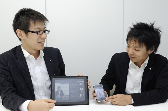 Actibookによる電子書籍が表示されたiPadとiPhoneを持つ小友氏（左）と北村氏（右）
