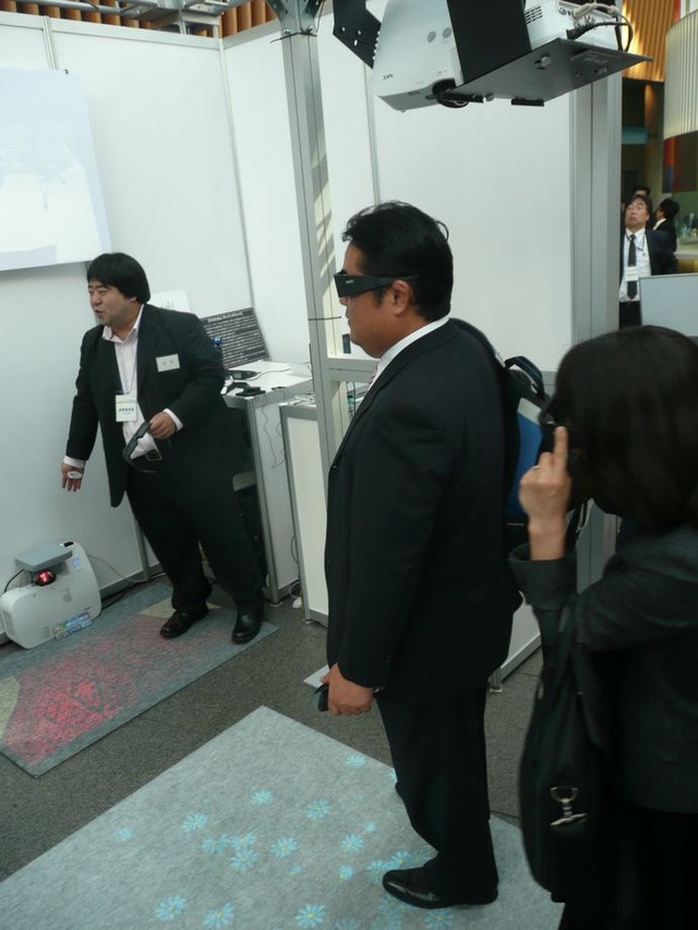 日本電子専門学校と共同でNECが開発したもので、ユーザーがマットの上に足を置くと、その動きに合わせてCGキャラクターが投影される。2台のプロジェクターで同期をとりながら映像を重ねている