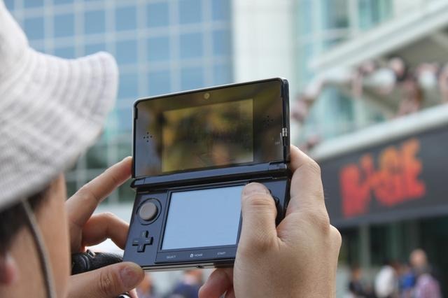 【E3 2011】閉幕後の会場前、みんなで3DSの画面を覗き込んで・・・  【E3 2011】閉幕後の会場前、みんなで3DSの画面を覗き込んで・・・ 