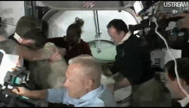ISSのクルーに出迎えられるアトランティスの搭乗員。画面右端に見えるカメラを持つのは古川聡宇宙飛行士