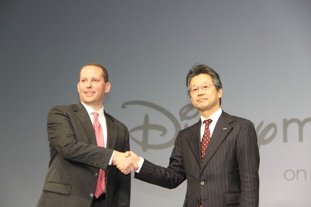 握手を交わすNTTドコモ永田氏とウォルト・ディズニー・ジャパンのミルスタイン氏