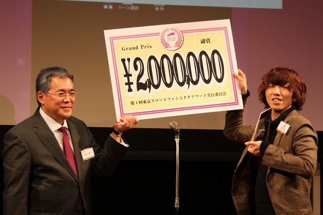寺山隆一実行委員長から200万円がエキサイトの小島靖彦氏に授与された