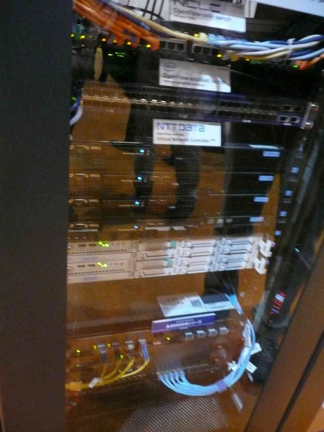 デモ4の該当部分のハードウェア。「バーチャルネットワークコントローラVer2.0」によって、hop-by-hopモデルとoverlayモデルを実現。OpenFlowスイッチにはインテルの「FM6000シリーズ」を搭載した参考品が使われた