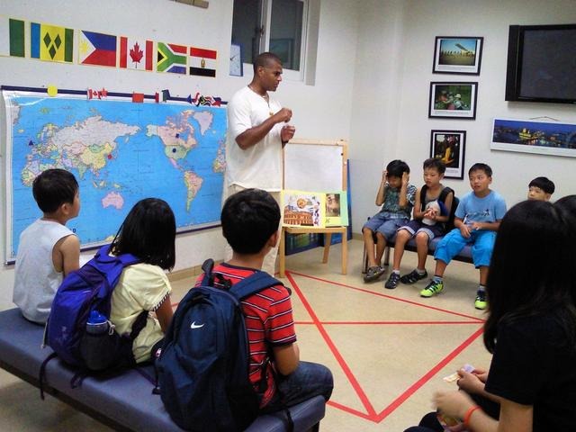 【パジュ英語村】世界地図を前に各国の特徴を英語で説明し、首都を言い当てるクイズをしている子どもたち