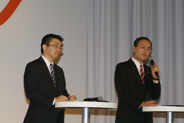 昨年1月の発表会で記者団の質問に答える田中孝司社長（右）と高橋誠専務