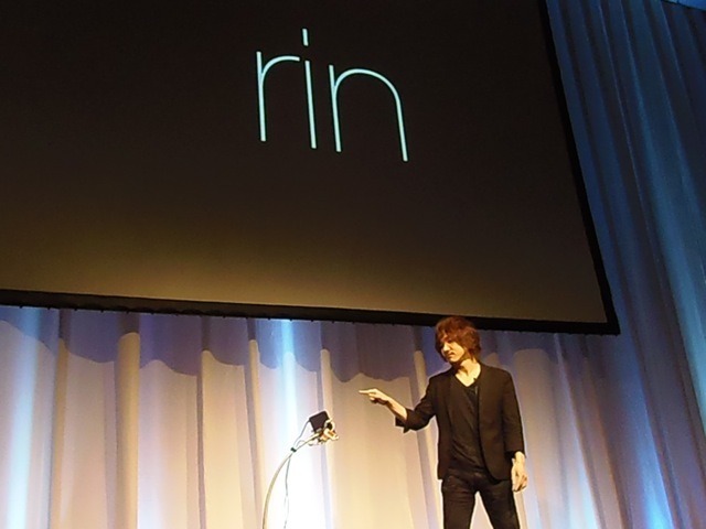 デモの様子その1。ジェスチャーで「Ring」という文字を入力。背景のスクリーンにデバイス上の文字が移し出されている