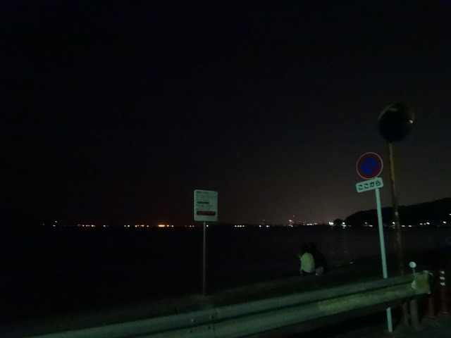 海岸沿いで夜空を見るカップル。福岡県西区にて