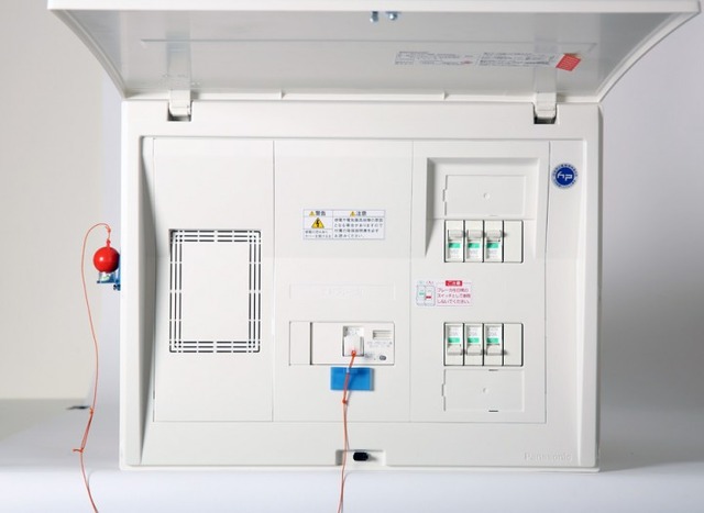 シンプルな構成で、設置も簡単に行える。ブレーカーのスイッチとヒモでつながったおもりが、一定以上の揺れにより落ちることで、ブレーカーを落とす仕組みとなっている（画像はプレスリリースより）