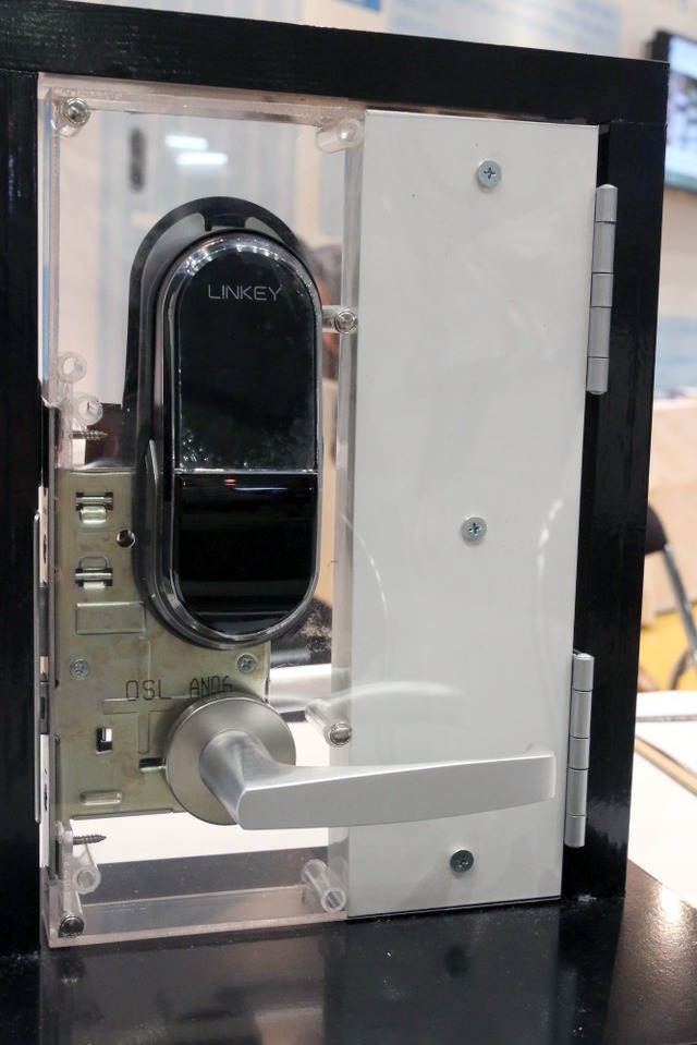ユーエムイーの「LINKEY」を設置イメージ。シリンダー（カギ穴など）の上から被せる形で設置する。この他にドアの内側にロック機構を設置する（撮影：防犯システムNAVI取材班）