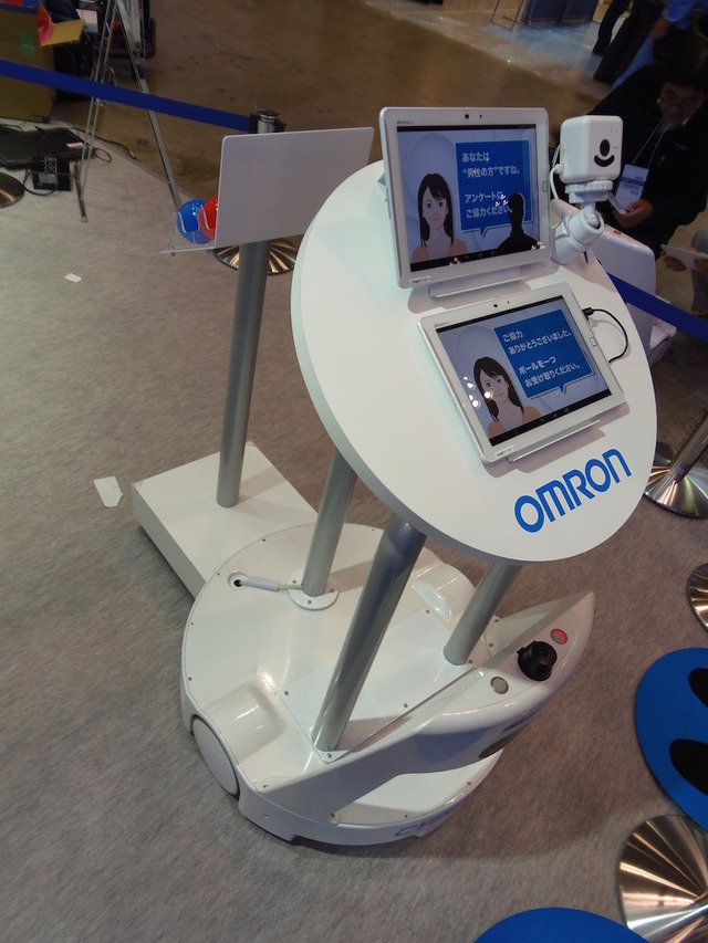 顔センシング技術「OKAO Vision」と組み合わせ、人をアシストする搬送ロボット。ベース部のAGVはサイバーダインの製品。OKAO Visionで、来場者の性別を判断する