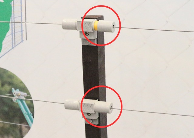上の丸囲みが自動復帰後のマーカー表示で、下の丸囲みが検知前のトラップ式フェンスセンサとなる（撮影：防犯システム取材班）
