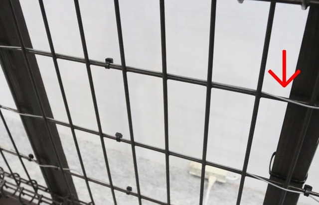 フェンスの金網部分への設置例。金網の編み目に沿って配線することで切り破りなどによる侵入を検知する（撮影：防犯システム取