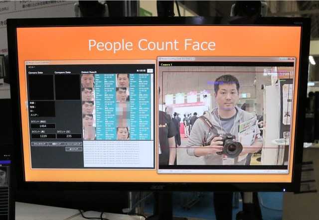 展示されていた「FACE」の表示画面。顔をとらえると男性なら青文字、女性なら赤文字で推定される年齢が表示される。使用するカメラや撮影環境により年齢の推定には誤差は出るが、デモ展示では筆者の年齢±1歳程度だった（撮影：防犯システム取材班）