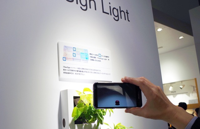 三菱側の展示ではそれぞれの照明で別々のコンテンツを表示させていた。室内の一般的な照明とは別に、指向性のあるLED照明の周りでスマートフォンをかざすことでコンテンツを表示する（撮影：防犯システム取材班）
