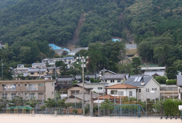 2014年8月に発生した豪雨よる広島市北部の土砂災害では、避難勧告は災害発生後に発表された。こうしたケースは“想定外”の要素が加わった時には十分に起きうるという。写真は、大きな被害があった広島市安佐南区。現在でも山肌には生々しい土砂災害の跡が残っている（撮影：防犯システム取材班）