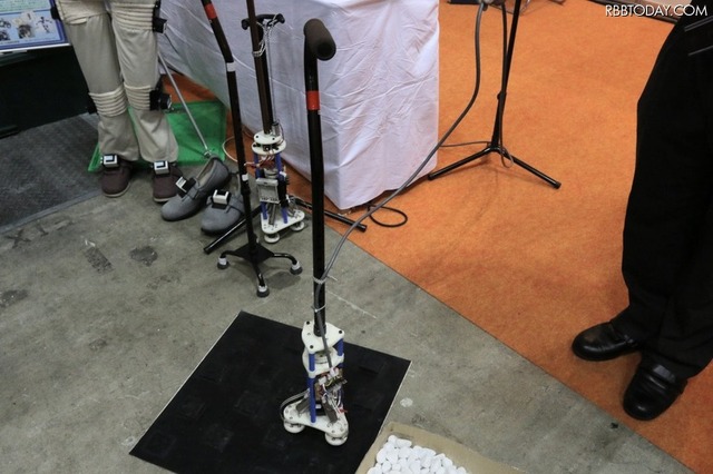 静岡大学応用ロボットシステム研究室が開発中のロボット歩行補助杖。MR流体（磁気粘性流体）を制御する電源には単3乾電池を使用していた（撮影：防犯システム取材班）