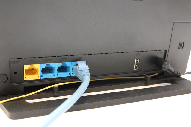 通信ONUのバックパネル。LANポートが全部で3口用意されている。黄色い配線は放送ONUから延びる光ファイバー