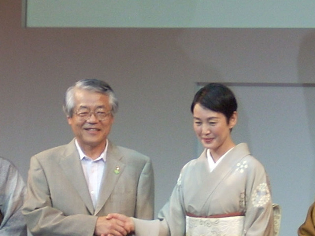 松下電器産業代表取締役副社長・牛丸俊三氏（左）と握手を交わす樋口さん
