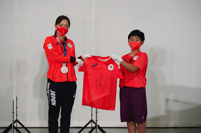 エスコートキッズにサイン入り「TEAM RED T シャツ」をプレゼントする石川佳純選手