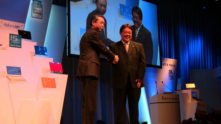 檀上で握手を交わす、パナソニック原田BU長と、インテル宗像副社長