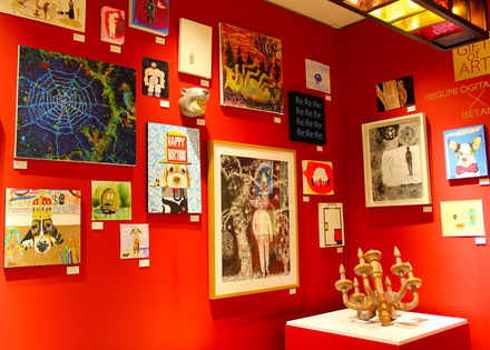 クリスマスを意識した赤い壁に展示される作品たち