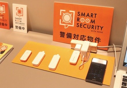 月々500円（税別）で留守中の不正な侵入を検知することができる「SMART ROOM SECURITY」の基本セット。左から、リモコン、マグネットセンサー2個、親機（コンセントに挿されているもの）（撮影：防犯システム取材班）