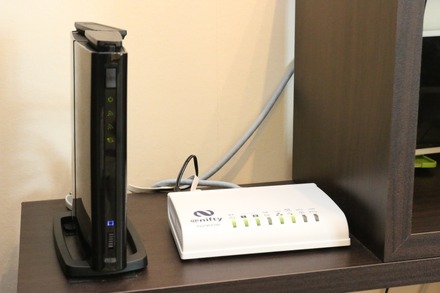 「スマートサーブ」のサービスアダプターと接続するブロードバンドルーター(撮影:防犯システム取材班)