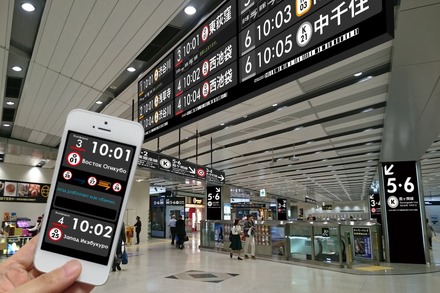 駅の行先案内表示器への設置を想定したイメージ。スマホでバーコードを読み取らせることで、行先案内表示器の内容を任意の言語で表示させることができる（画像はプレスリリース）