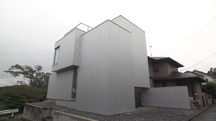 シルバーのガルバリウム鋼板に覆われ、窓が1つもない正面側の外観©MBS